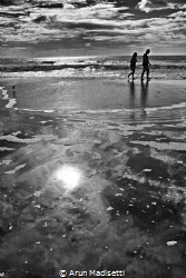 A day at the beach. People walking the surf line at Myrtl... by Arun Madisetti 